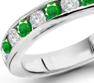 sleek half eternity ring with diamonds and emeralds