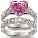 An audacious De Beers ring has a princess center stone on a wide baguette-cut diamond band